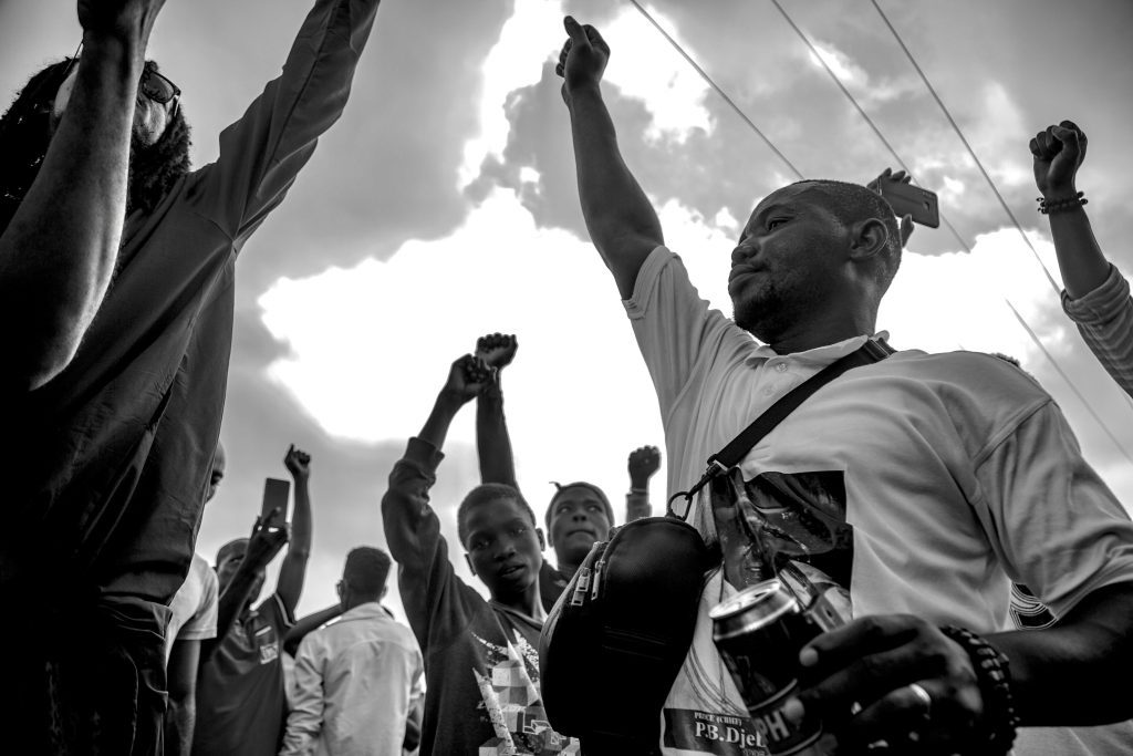 Young people with hands raised at an open-air gathering