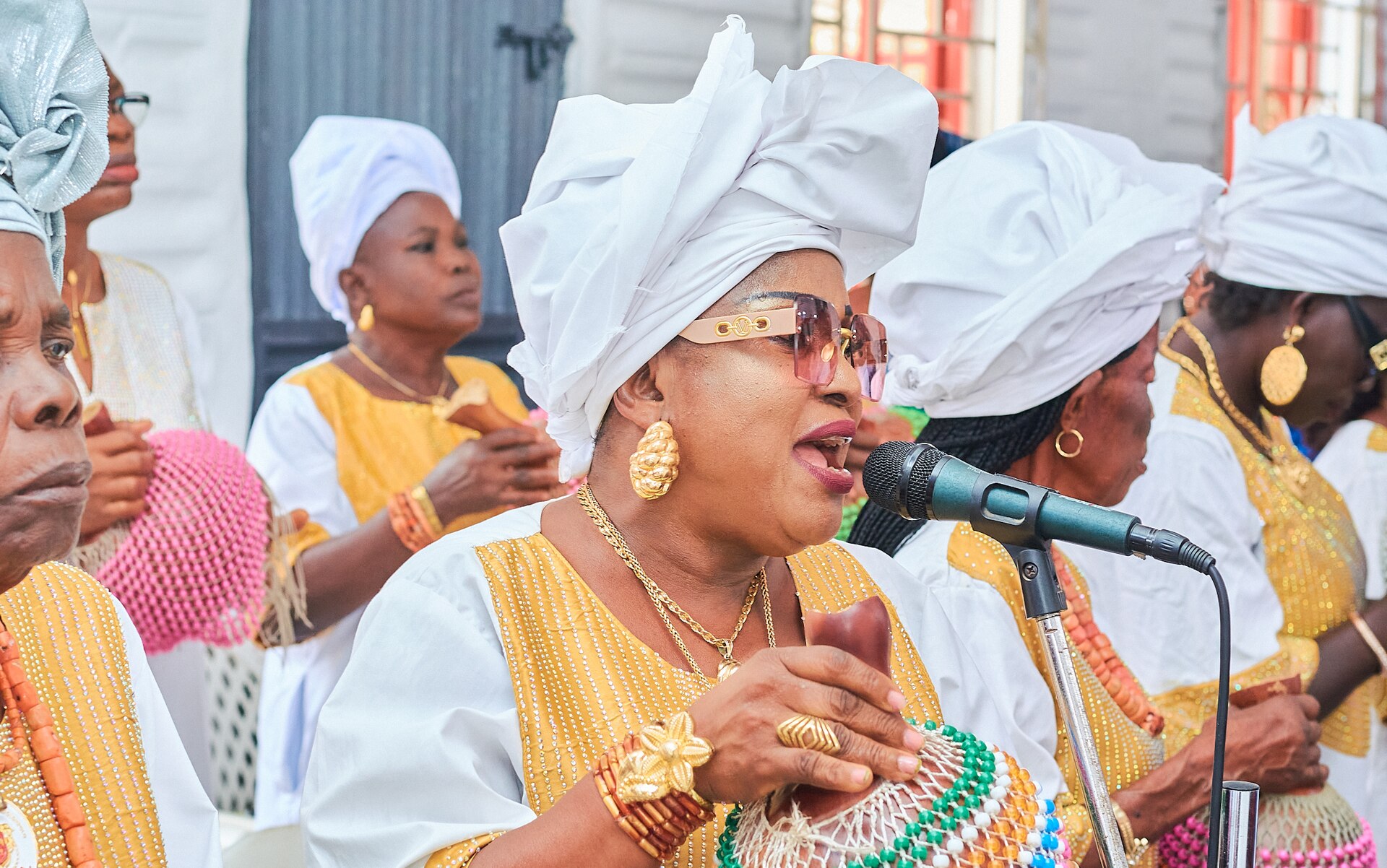A choir in white and gold leading worship in song