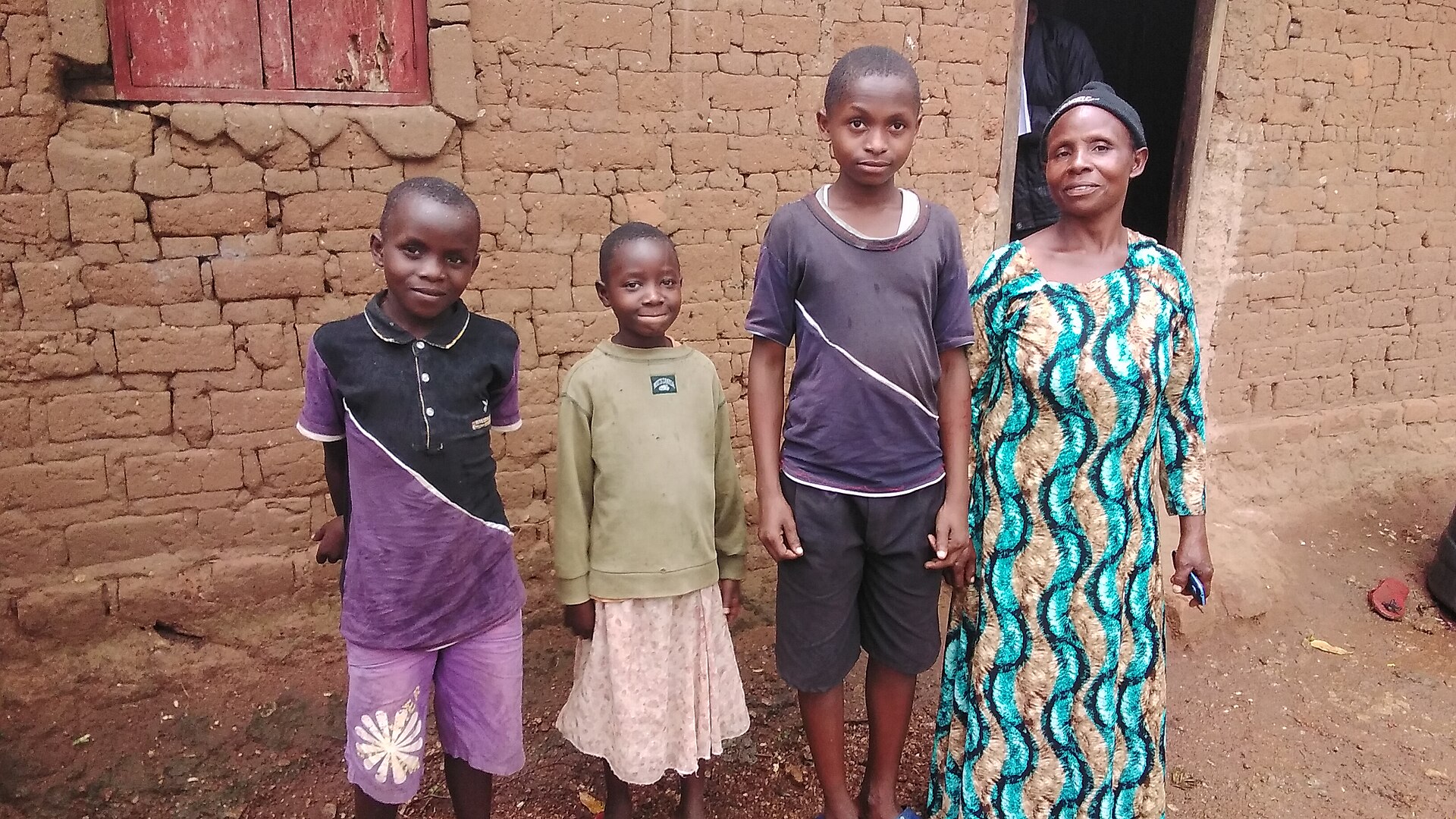 A mother with her children outside their home