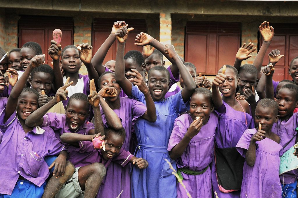 Schoolchildren in purple uniforms cheering with joy