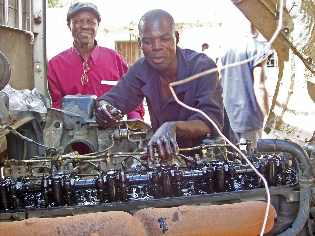 A young mechanic learning his trade on an engine